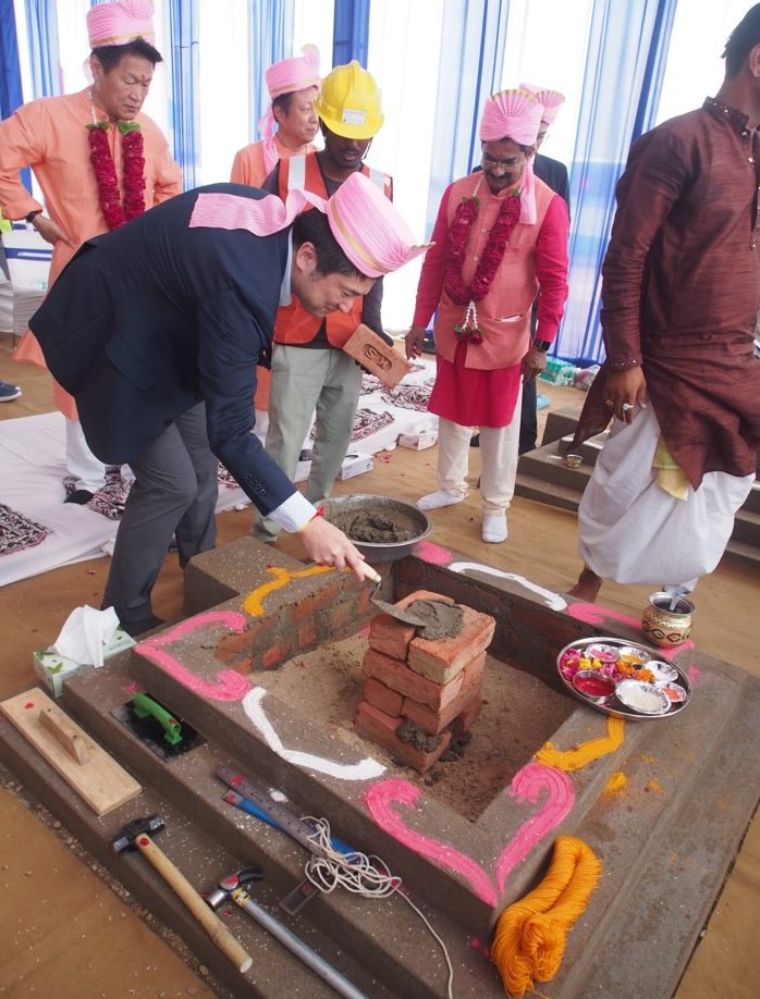 Mr Satoru Oto, putting cement on the bricks, which is initiation of construction.